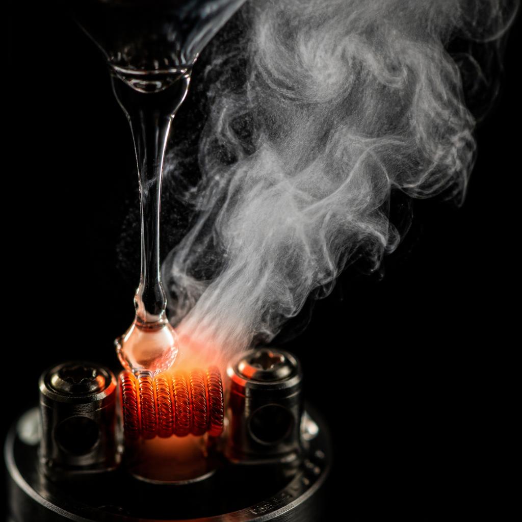 Macro photograph of e-liquid turning into aerosol above a hot coil